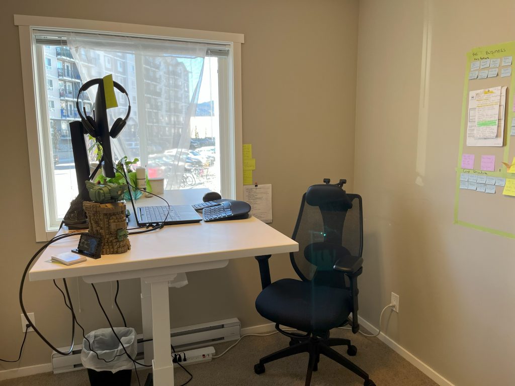 Dhorea's workstation set-up with a monitor, ergonomic chair, keyboard, and mouse