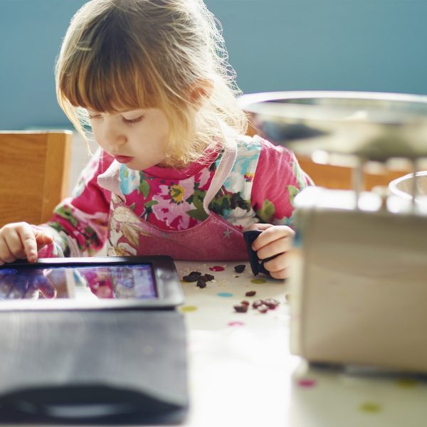 a young girl plays on a tablet