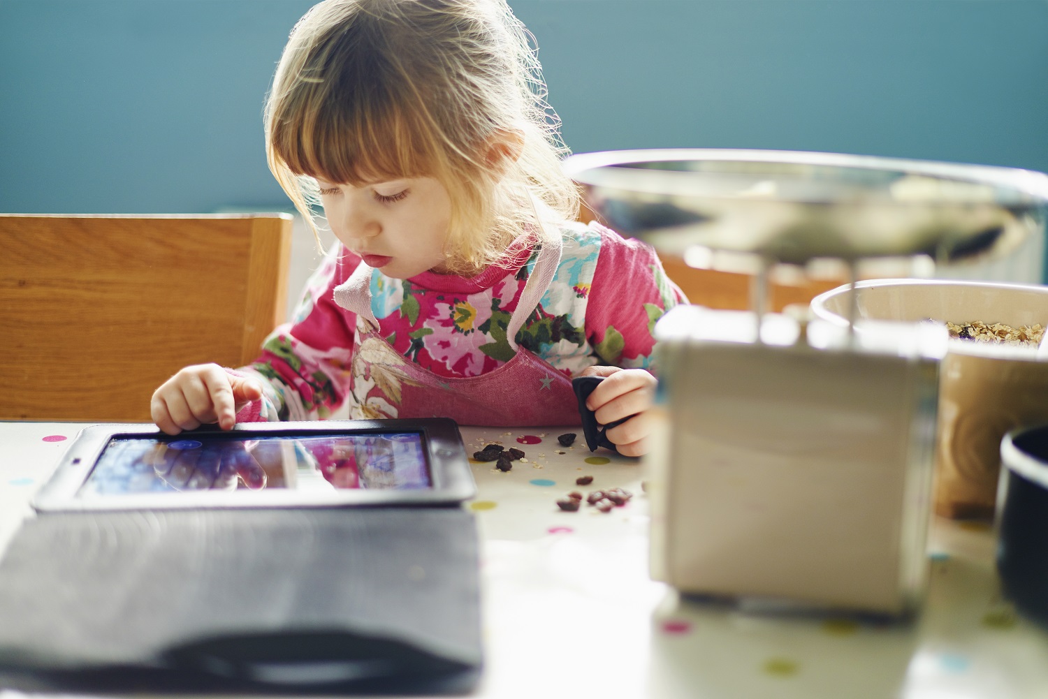 a young girl plays on a tablet