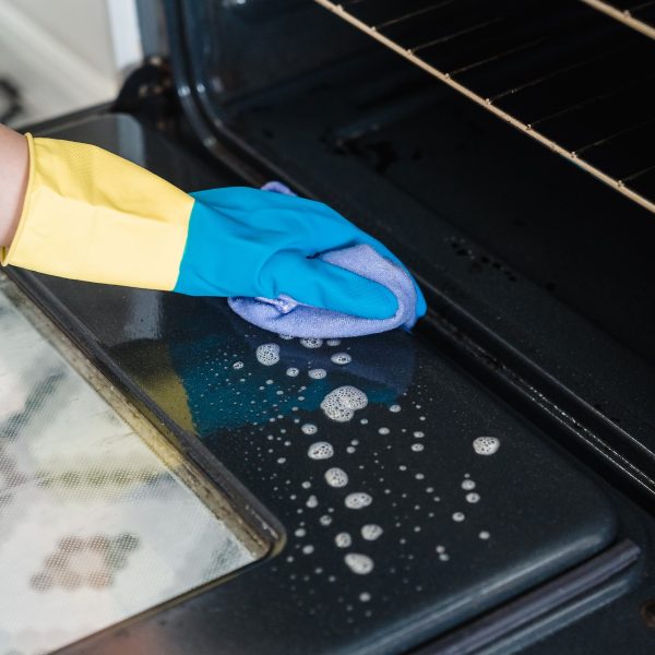 a cleaner cleaning an oven door