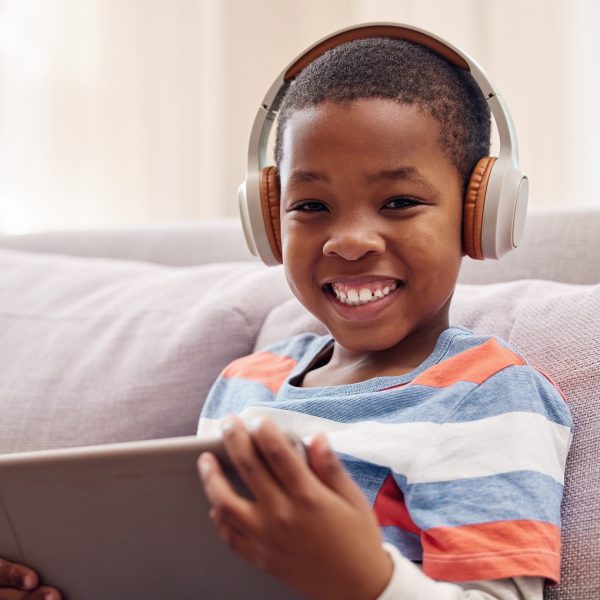 A young boy using a digital tablet while relaxing at home.