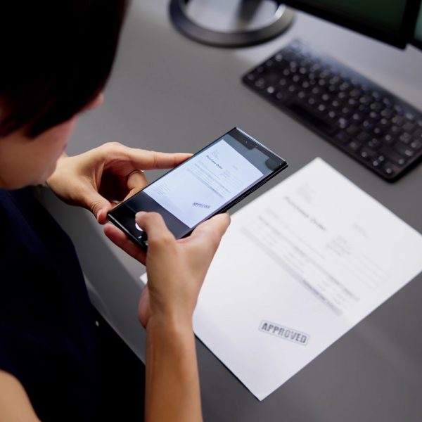 A woman scans an invoice with her phone.