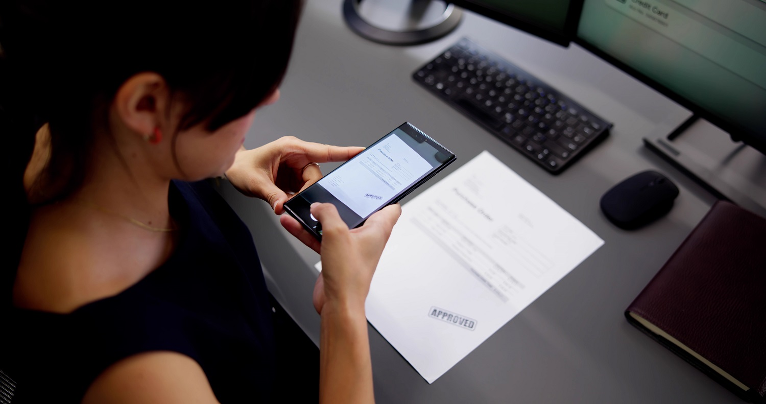 A woman scans an invoice with her phone.