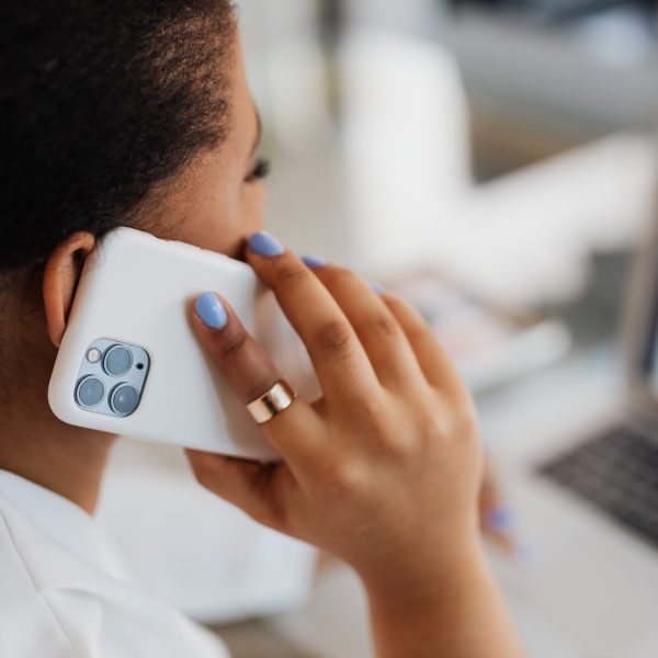 A woman talks on her phone at her desk.