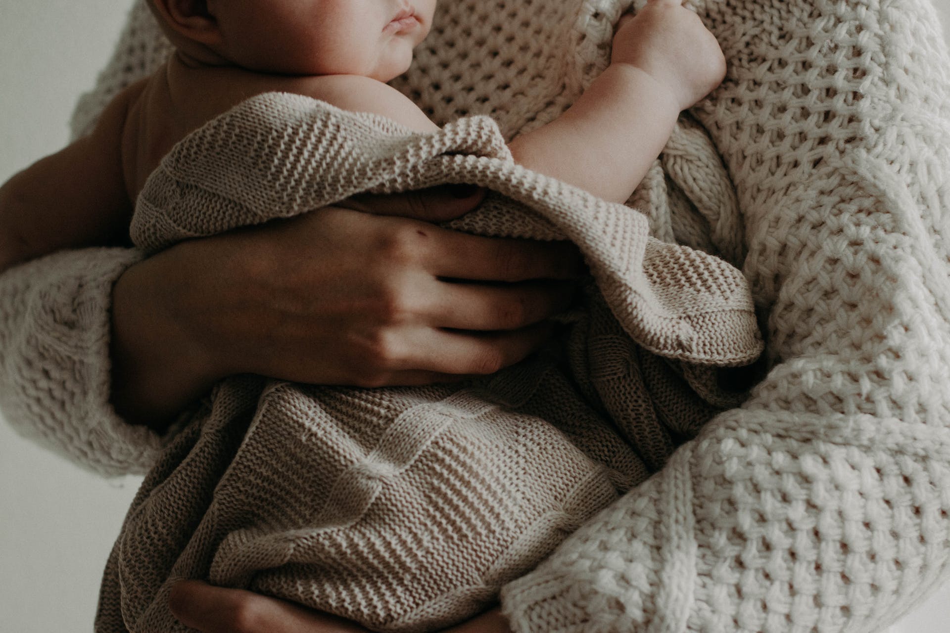 A mother embracing a baby.