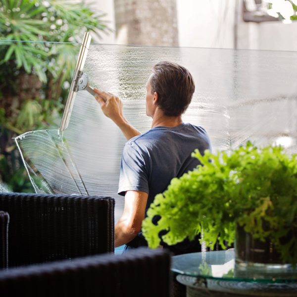 A man cleans a glass window.