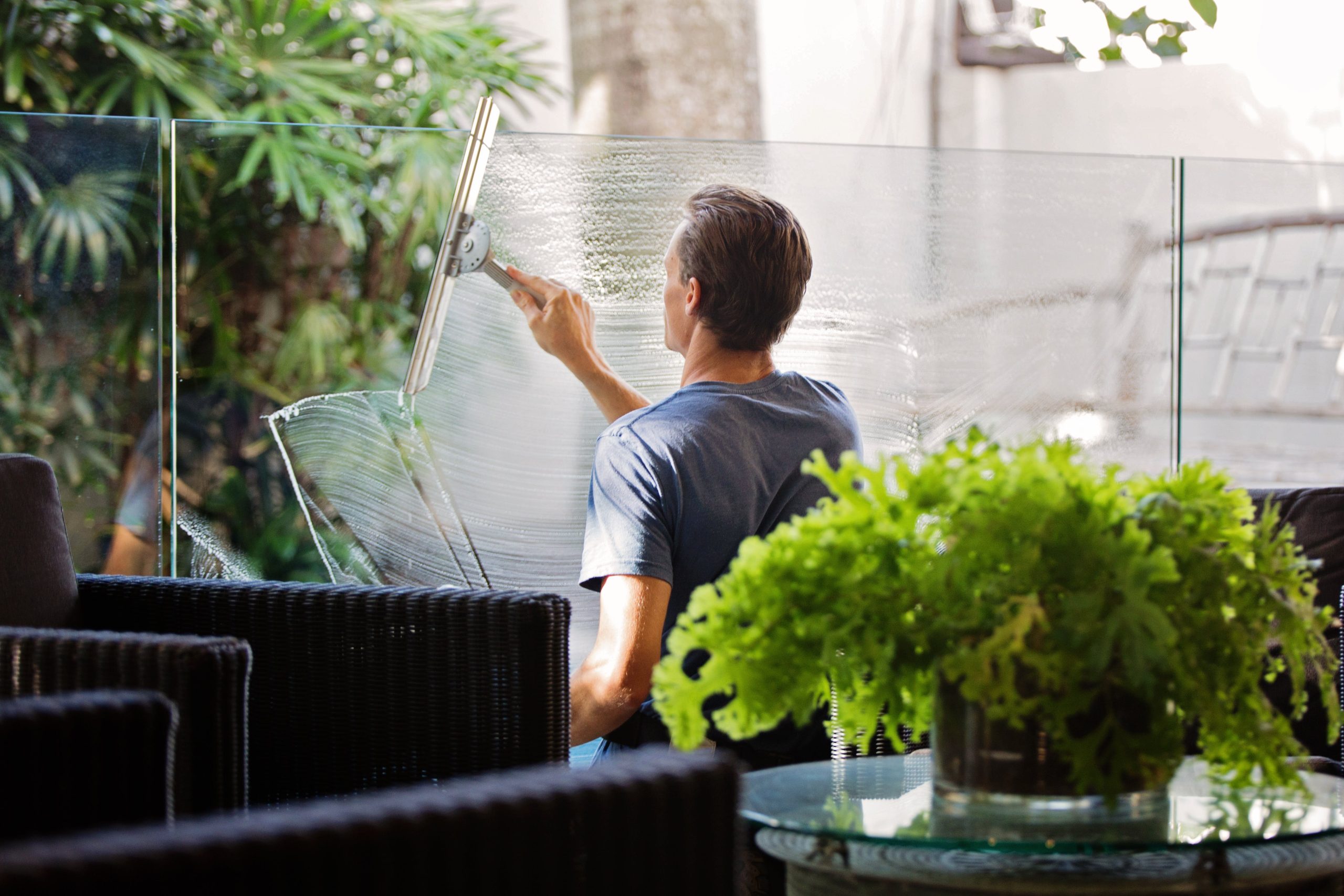 A man cleans a glass window.