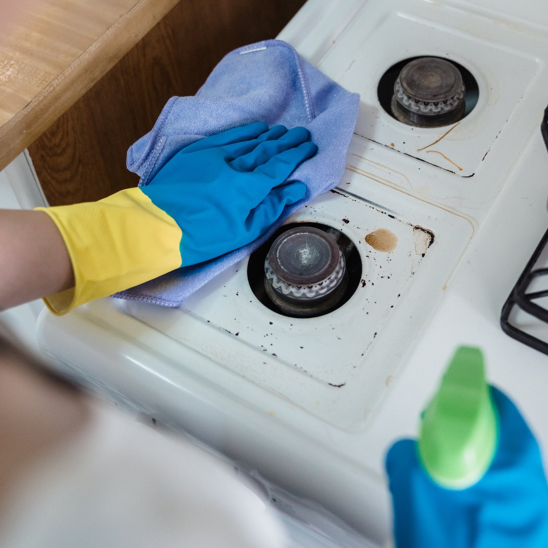 A person cleans a stove.