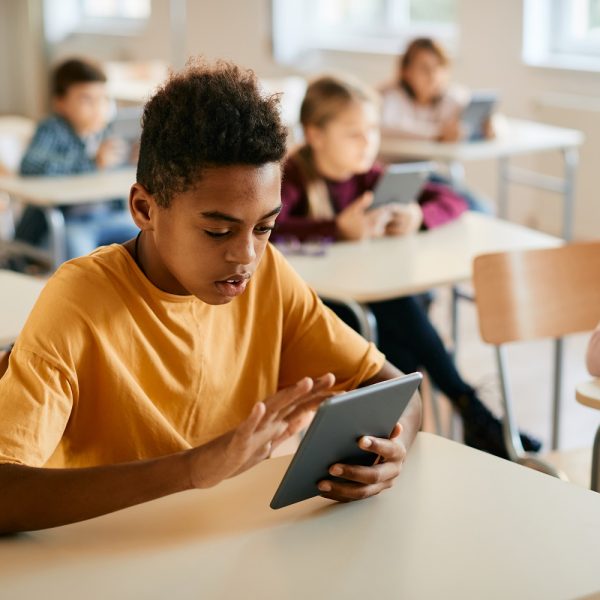 A boys uses a tablet in the classroom.