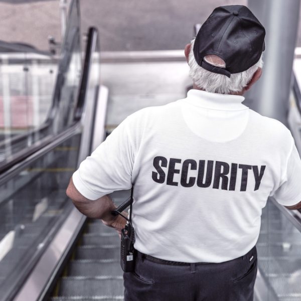 A security guard going down an escalator.