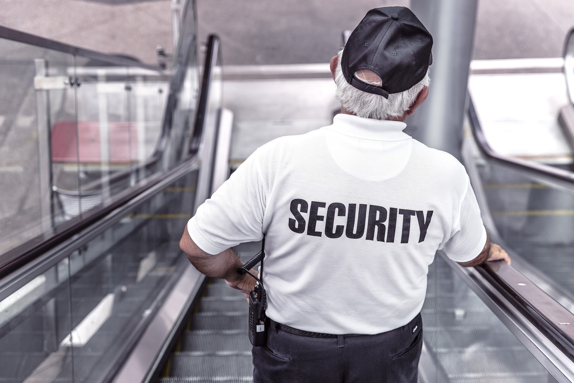 A security guard going down an escalator.