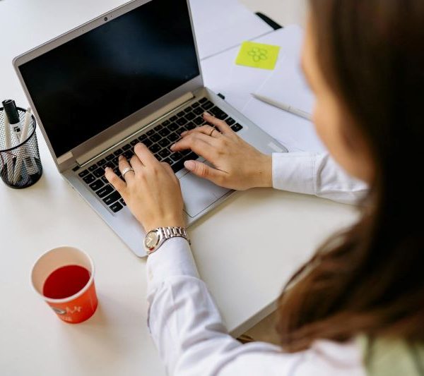 A woman types on a laptop.