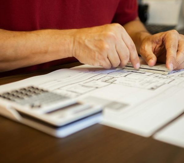 A man measures architectural plans.