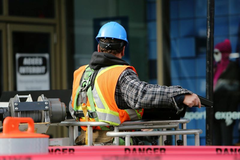A man wearing a high vis vest and a hard hat at a construction site.