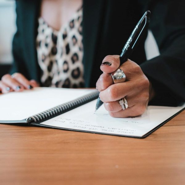 A woman writes in a notebook.