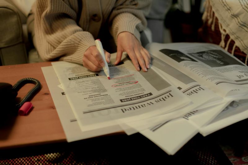 A person circles a classified ad in a newspaper.