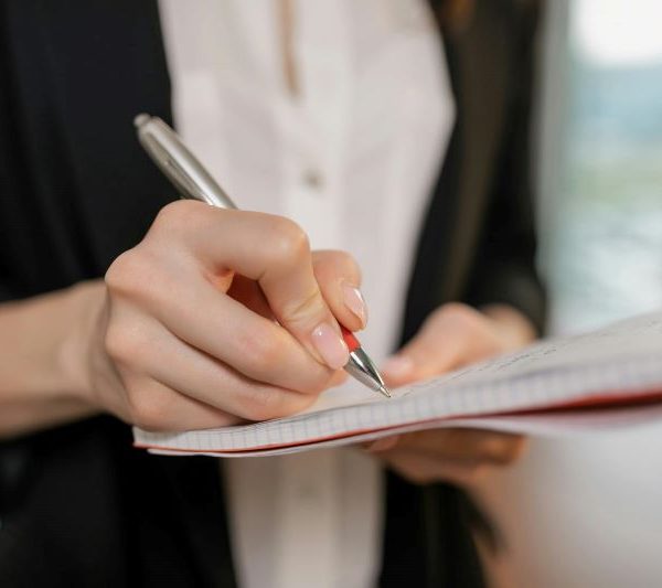 A person writes in a notebook.