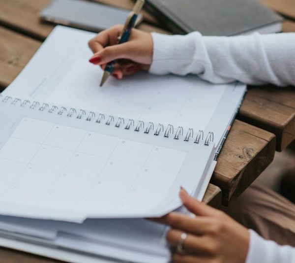 A person writes in a notebook.