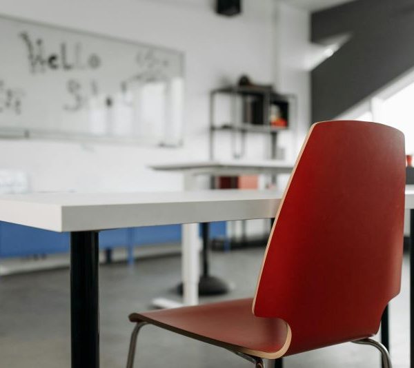 A chair at a desk facing a whiteboard in a classroom.