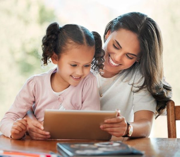 A mother watches something on a tablet with a child.