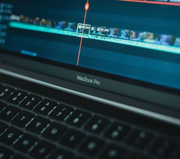 A person uses video editing software on their laptop.